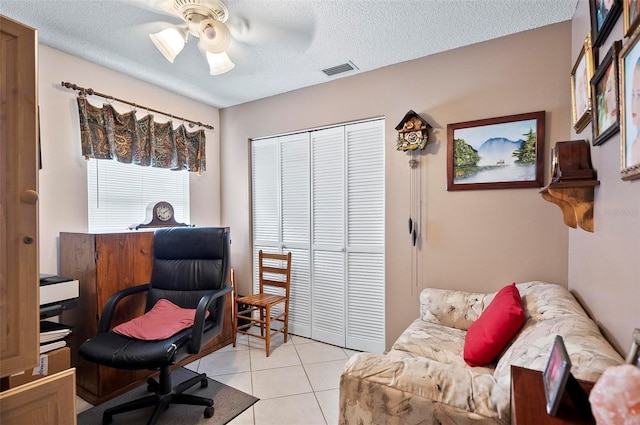 office space with a textured ceiling, ceiling fan, and light tile patterned flooring