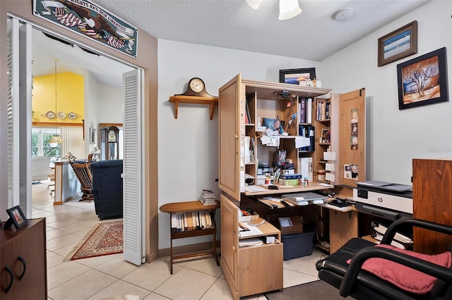 tiled office with a textured ceiling and vaulted ceiling