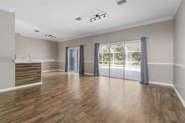 unfurnished room featuring ornamental molding, a textured ceiling, track lighting, and dark wood-type flooring