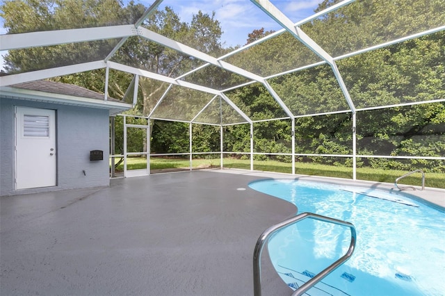 view of pool with a patio area and glass enclosure