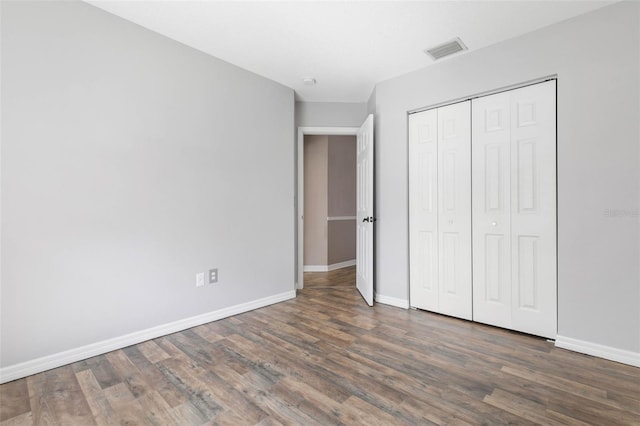 unfurnished bedroom with a closet and dark wood-type flooring