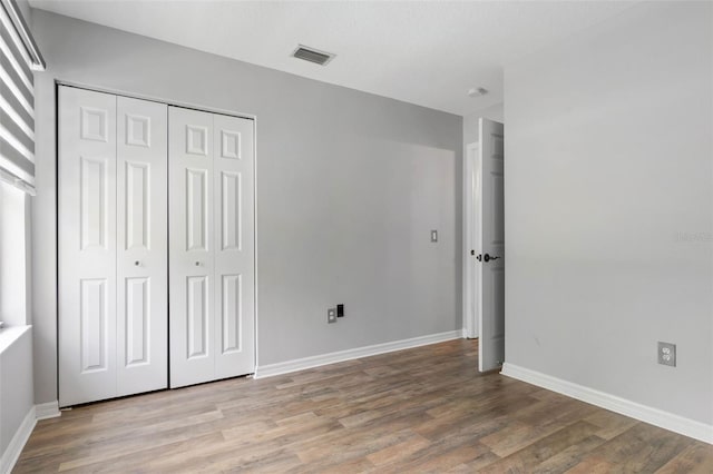 unfurnished bedroom with a closet and hardwood / wood-style floors