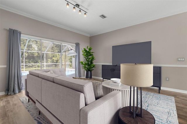 living room with crown molding, track lighting, and hardwood / wood-style flooring