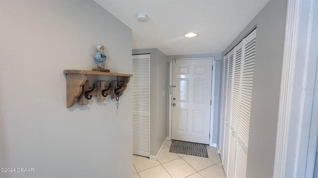 entryway featuring light tile patterned floors and baseboards