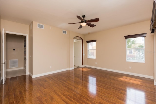 unfurnished room with dark hardwood / wood-style floors, ceiling fan, and a wealth of natural light