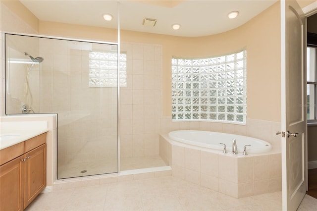 bathroom with tile patterned flooring, vanity, and separate shower and tub