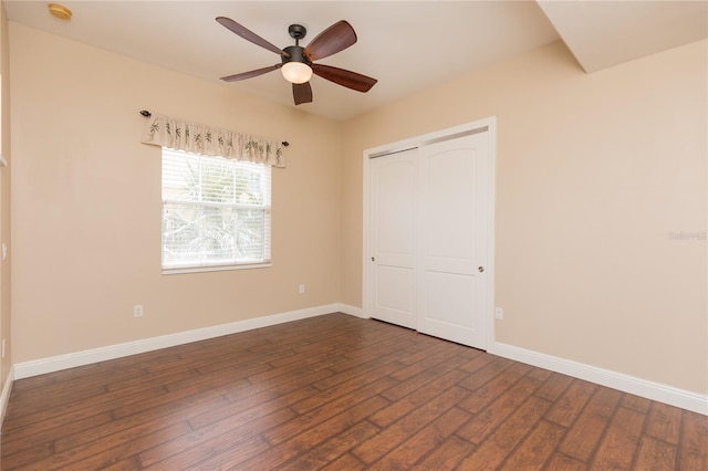 unfurnished bedroom with ceiling fan, dark wood-type flooring, and a closet