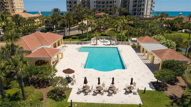 view of swimming pool featuring a patio and a water view