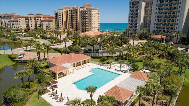 view of swimming pool with a water view and a patio area