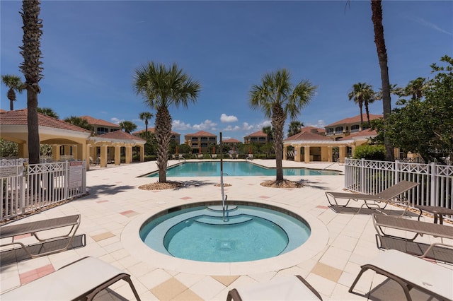 view of swimming pool featuring a hot tub and a patio area