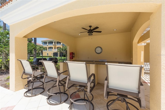 view of patio with exterior bar and ceiling fan