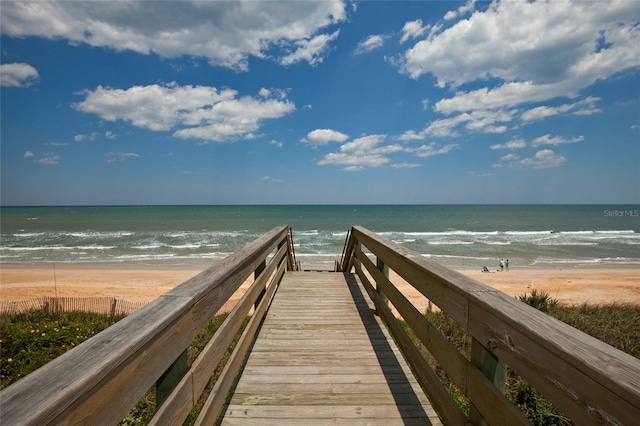 view of property's community featuring a water view and a beach view