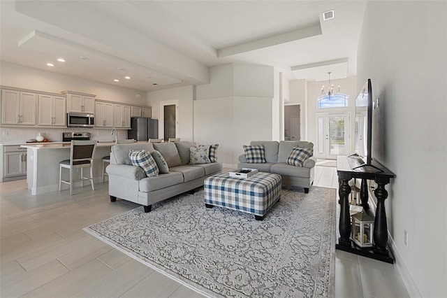 living room with a notable chandelier and light hardwood / wood-style flooring