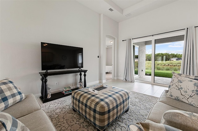 tiled living room featuring a towering ceiling