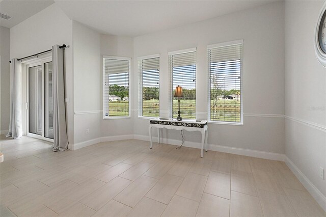 tiled spare room featuring a healthy amount of sunlight