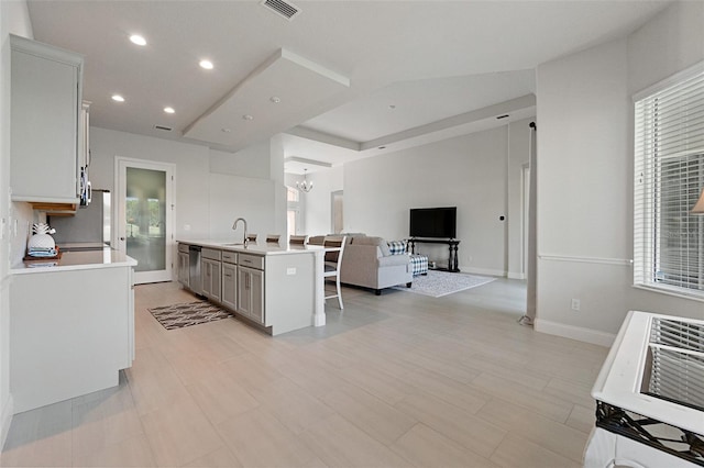 kitchen with gray cabinets, sink, a kitchen island with sink, and a healthy amount of sunlight