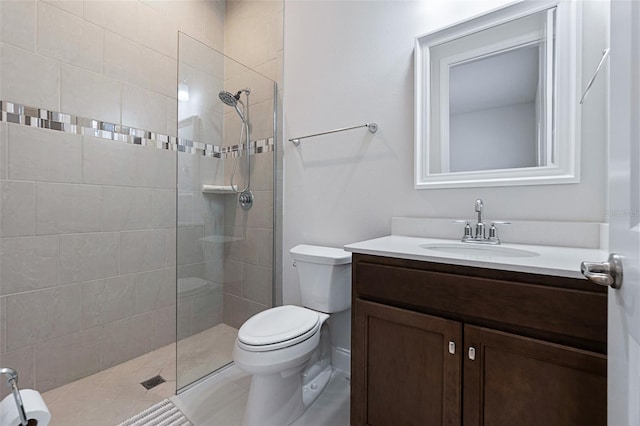 bathroom featuring tiled shower, toilet, and vanity