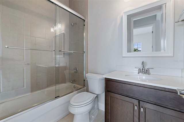 full bathroom featuring tile patterned flooring, vanity, toilet, and bath / shower combo with glass door