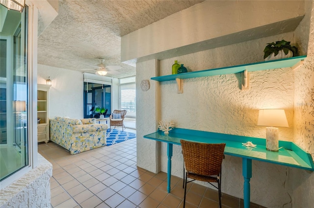 interior space with ceiling fan, a textured ceiling, and tile patterned flooring