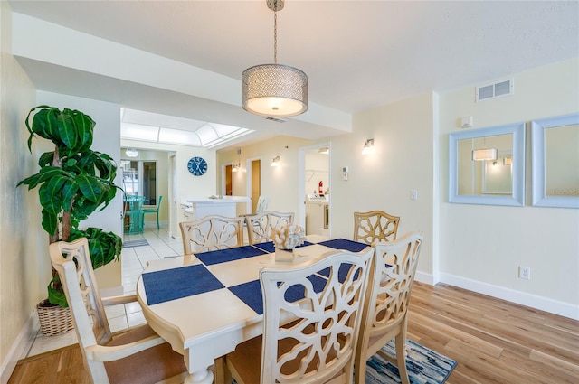 dining space with light wood-type flooring and washing machine and dryer