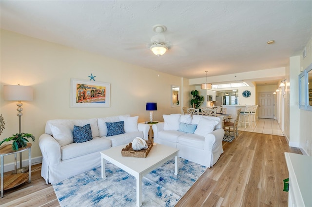 living room featuring light wood-type flooring and ceiling fan