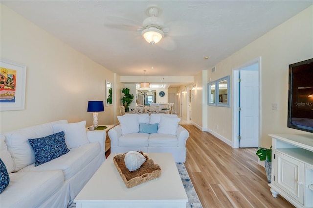 living room with ceiling fan and light hardwood / wood-style flooring