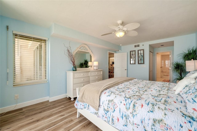 bedroom with ceiling fan, ensuite bath, and light hardwood / wood-style floors