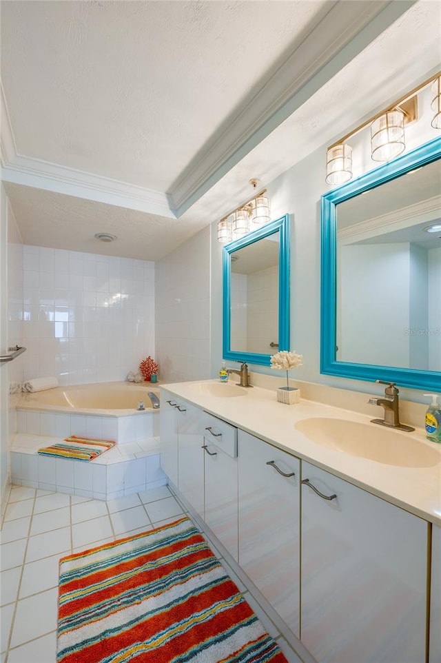 bathroom with tiled bath, vanity, a textured ceiling, tile patterned flooring, and ornamental molding