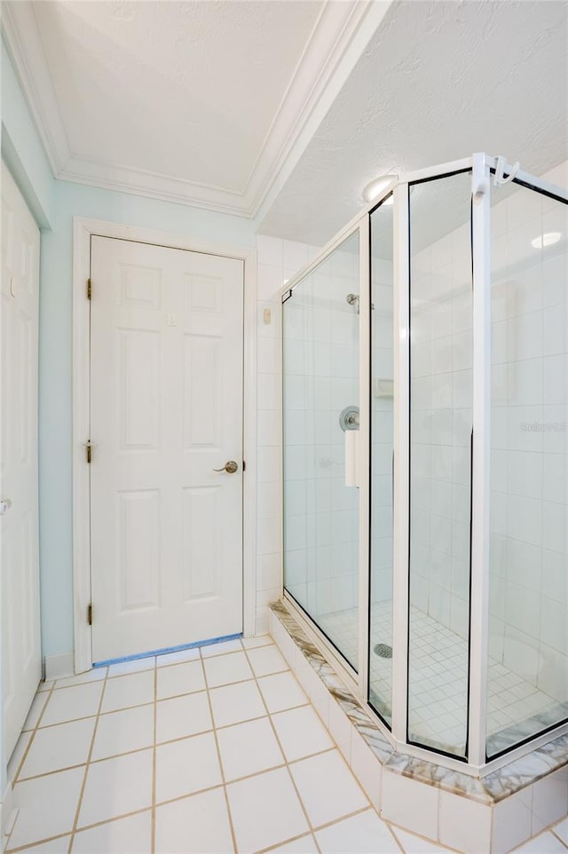 bathroom featuring ornamental molding, tile patterned flooring, a textured ceiling, and a shower with door