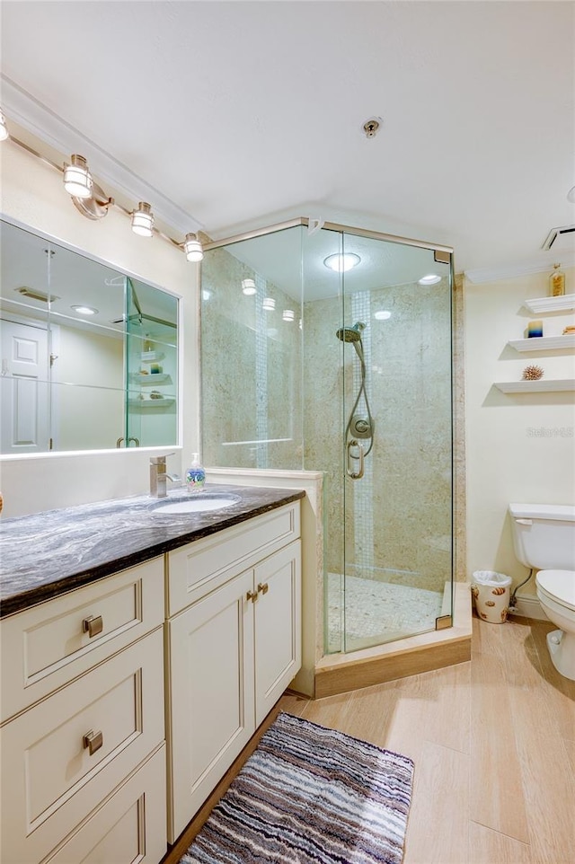 bathroom featuring walk in shower, vanity, toilet, and hardwood / wood-style flooring