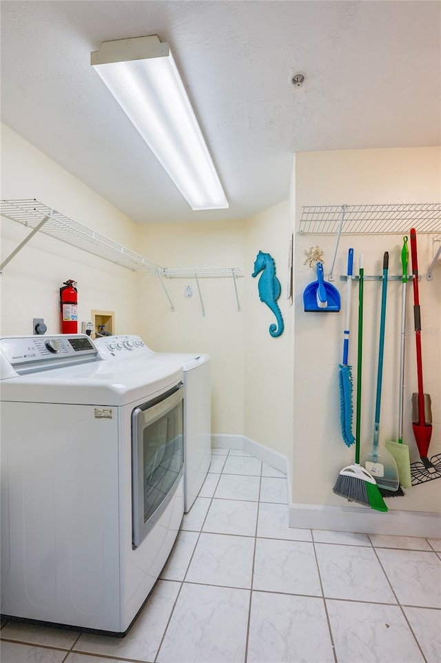 clothes washing area featuring light tile patterned floors and separate washer and dryer