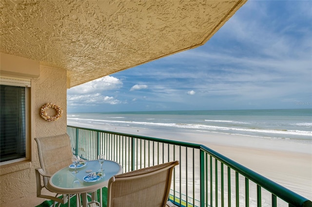 balcony featuring a water view and a view of the beach