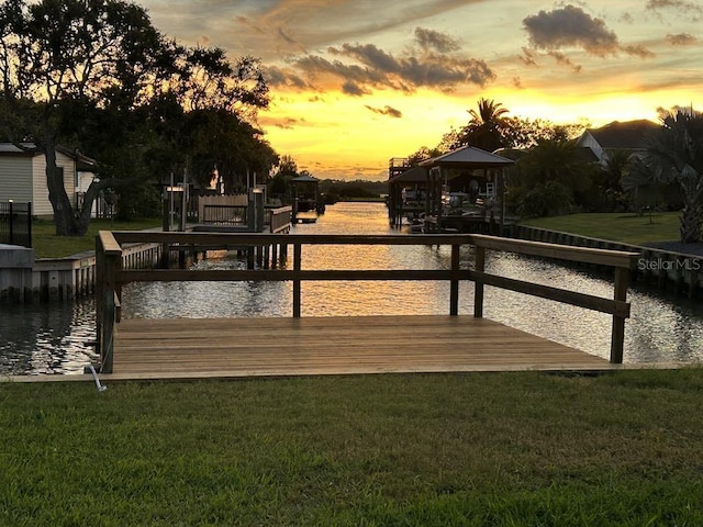 dock area featuring a water view, a yard, and a gazebo