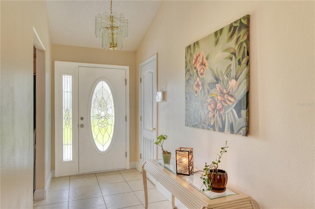 entryway with vaulted ceiling, plenty of natural light, light tile patterned floors, and a notable chandelier