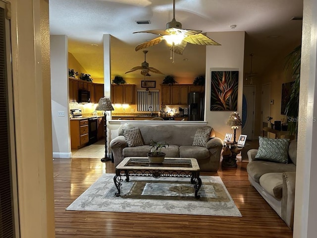 living room with light wood-type flooring and ceiling fan