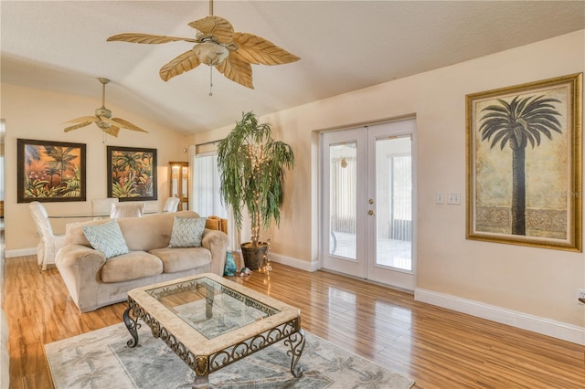 living room featuring light wood-type flooring, ceiling fan, lofted ceiling, and french doors