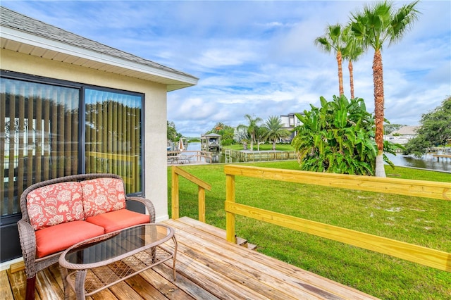 wooden terrace with a yard and a water view