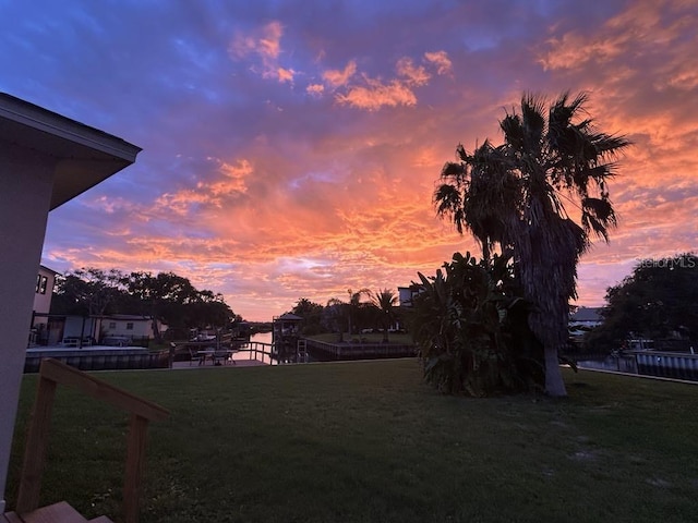 yard at dusk featuring a water view