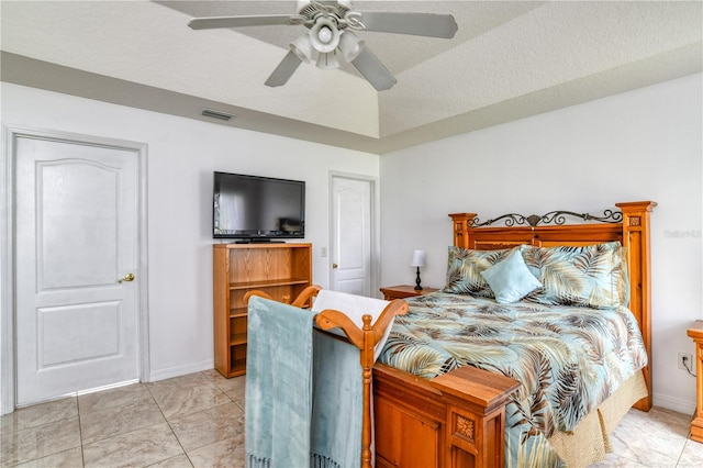 bedroom with a textured ceiling, ceiling fan, and light tile patterned floors