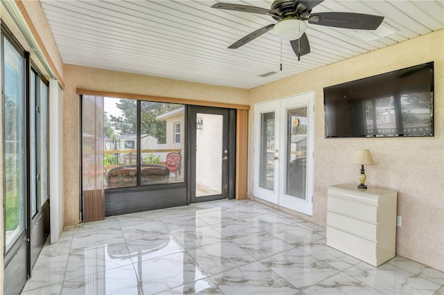 unfurnished sunroom featuring ceiling fan