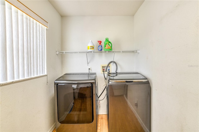 laundry area with washer and clothes dryer and hardwood / wood-style floors