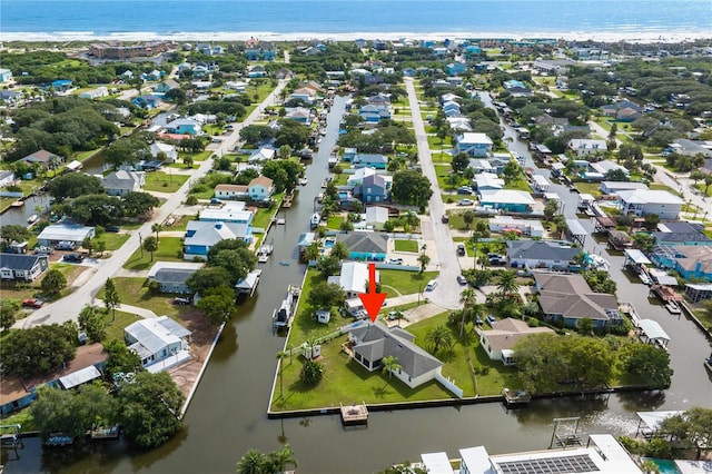 birds eye view of property featuring a beach view and a water view