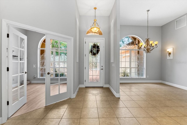 foyer entrance featuring tile patterned flooring, a notable chandelier, french doors, and visible vents