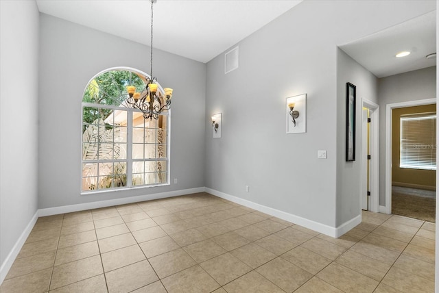 spare room featuring light tile patterned flooring, a notable chandelier, visible vents, and baseboards