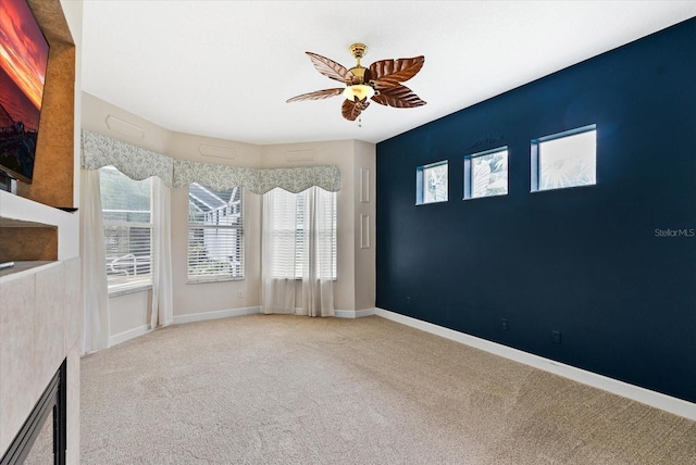 interior space with carpet flooring, a ceiling fan, and baseboards