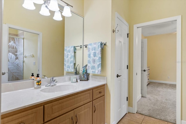 bathroom with tile patterned floors, baseboards, an inviting chandelier, and vanity