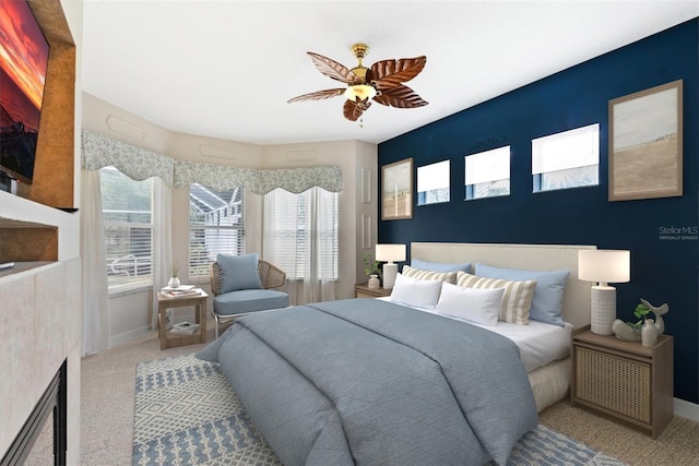 carpeted bedroom featuring multiple windows, baseboards, and a ceiling fan