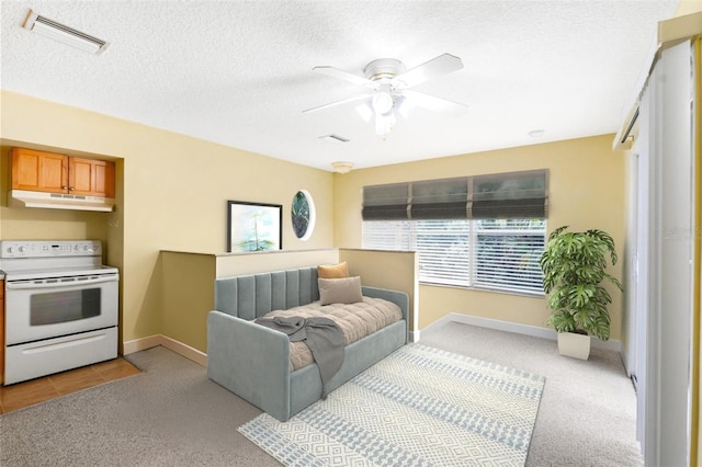 bedroom featuring light carpet, visible vents, a textured ceiling, and a ceiling fan