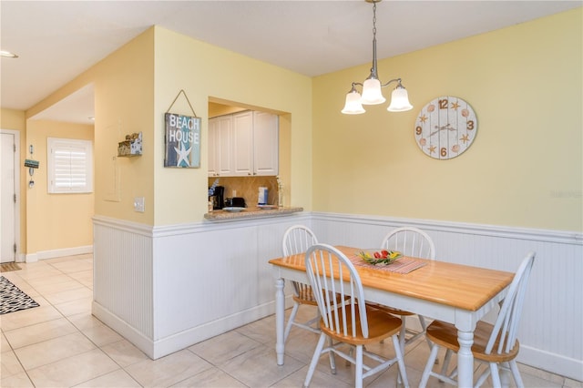 tiled dining area with a chandelier