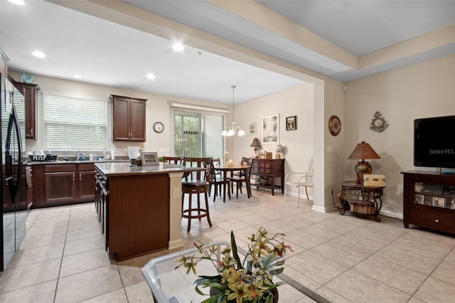 kitchen with a center island, pendant lighting, a notable chandelier, and light tile patterned floors